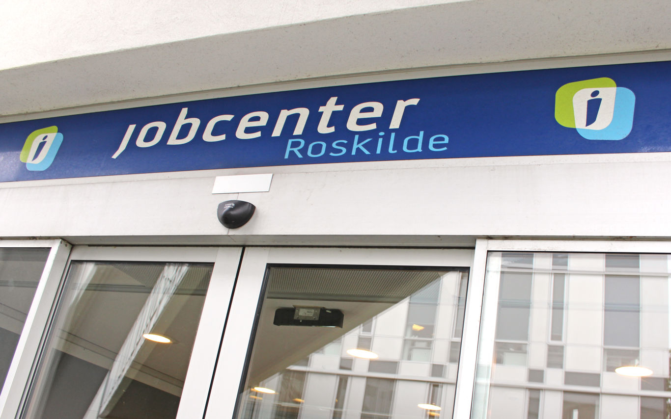 Jobcenter Roskildes indgangsparti med automatiske døre og et blåt skilt.