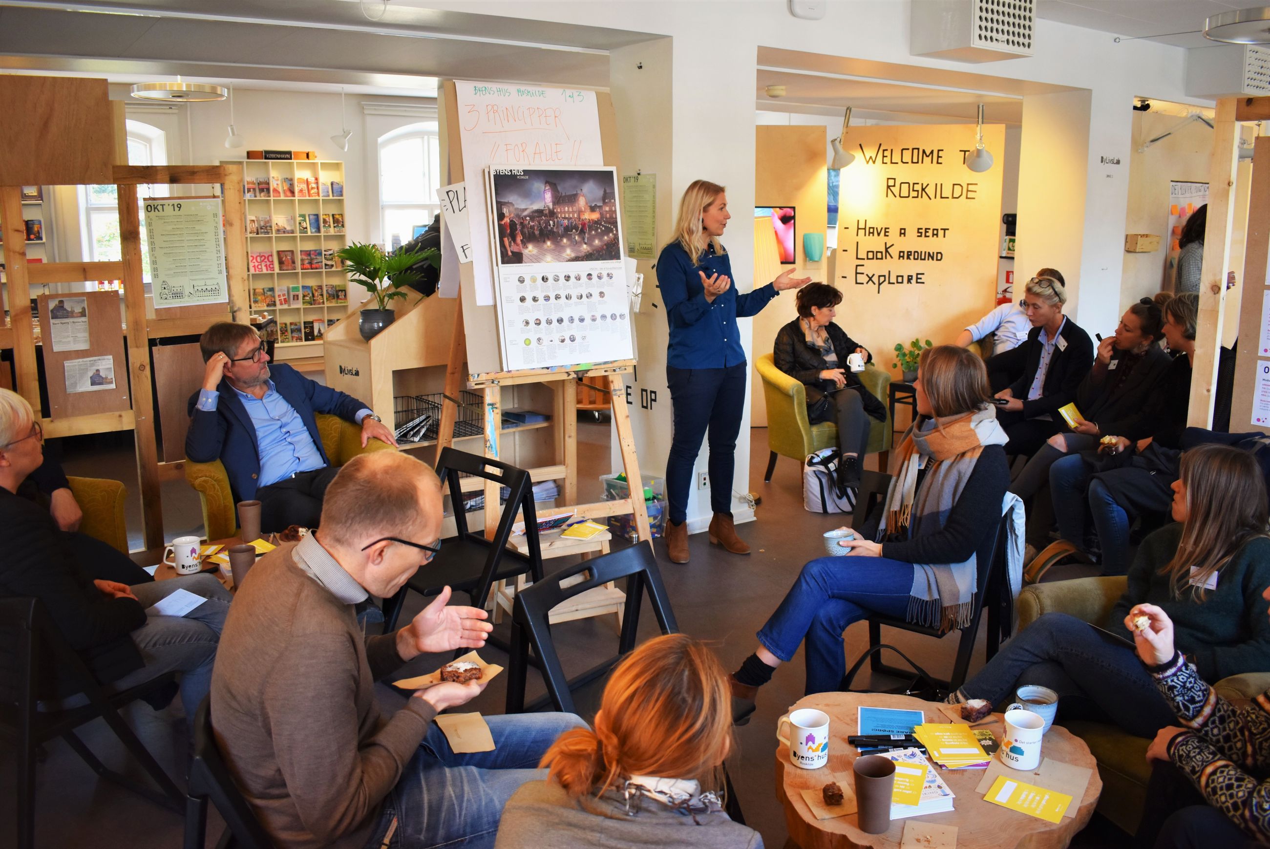 En gruppe mennesker til velkomstmøde i Byens hus