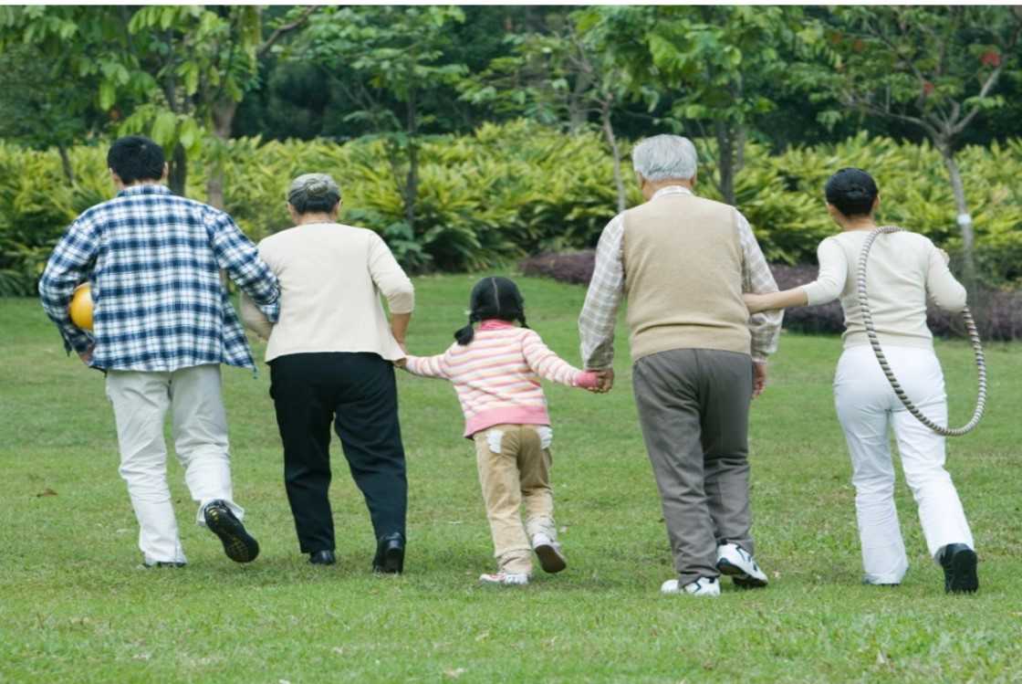 Fem mennesker går væk fra kameraet med ryggen til. Personen i midten er et barn.