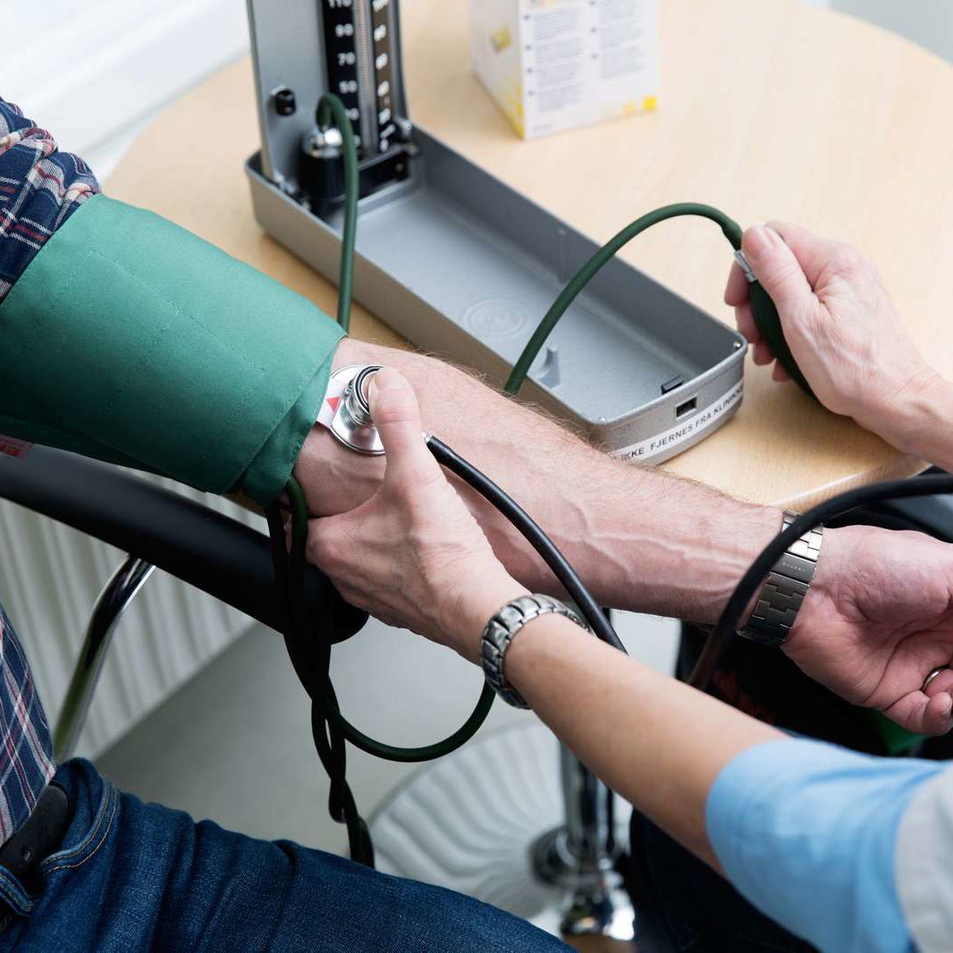 Læge tager blodtrykket på en patient.