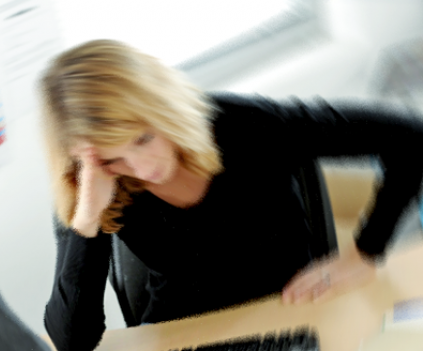 Person holder sig til hovedet. Billedet er sløret og kaotisk.