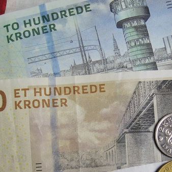 Pengesedler og mønter. En hundredekroneseddel, en tohundredekroneseddel og nogle småmønter.