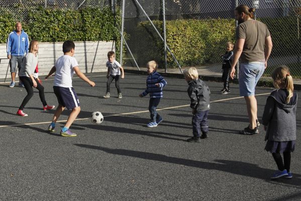Forældre og børn spiller fodbold