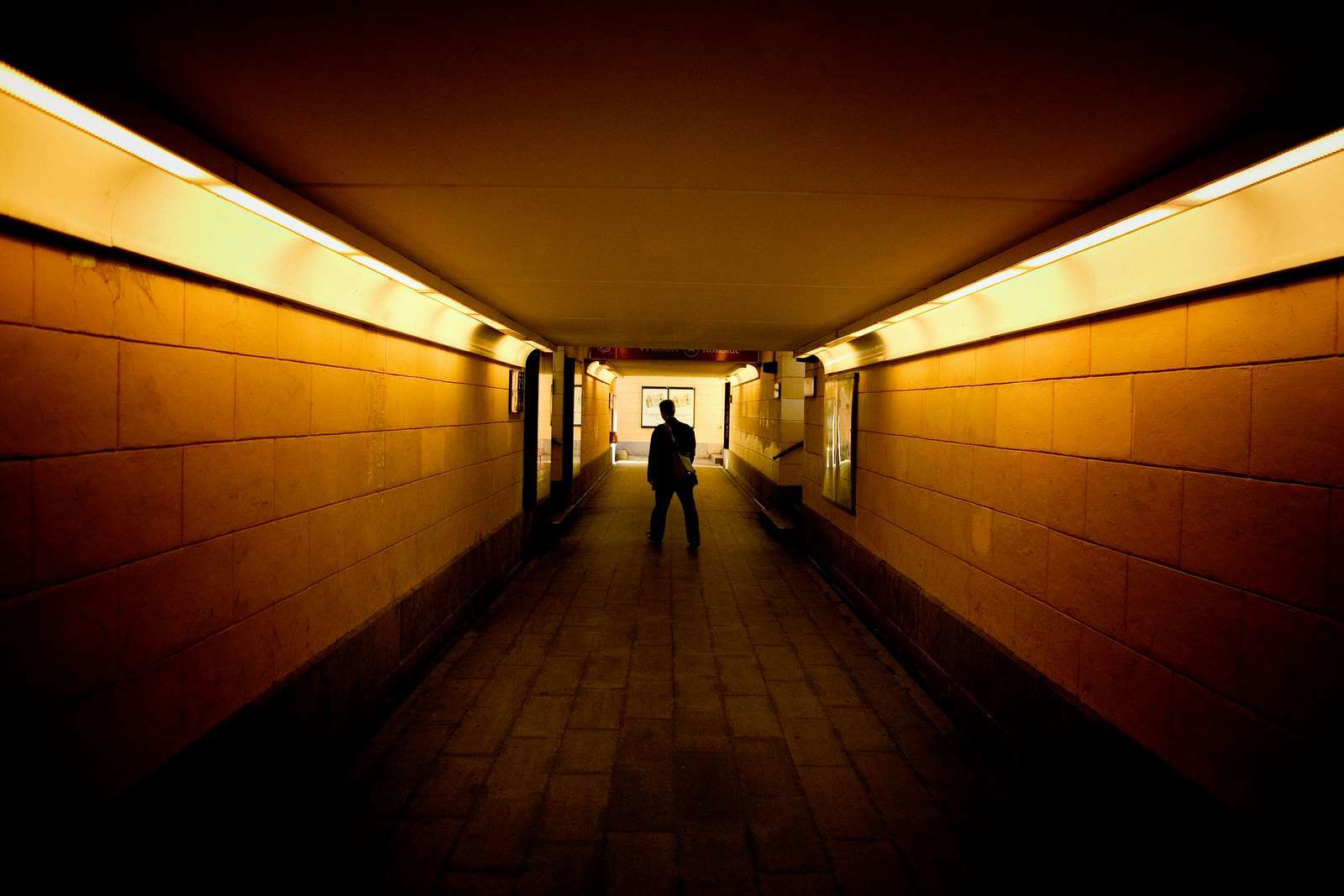 Tunnel under Roskilde Station. Der går en person et stykke væk fra kameraet.