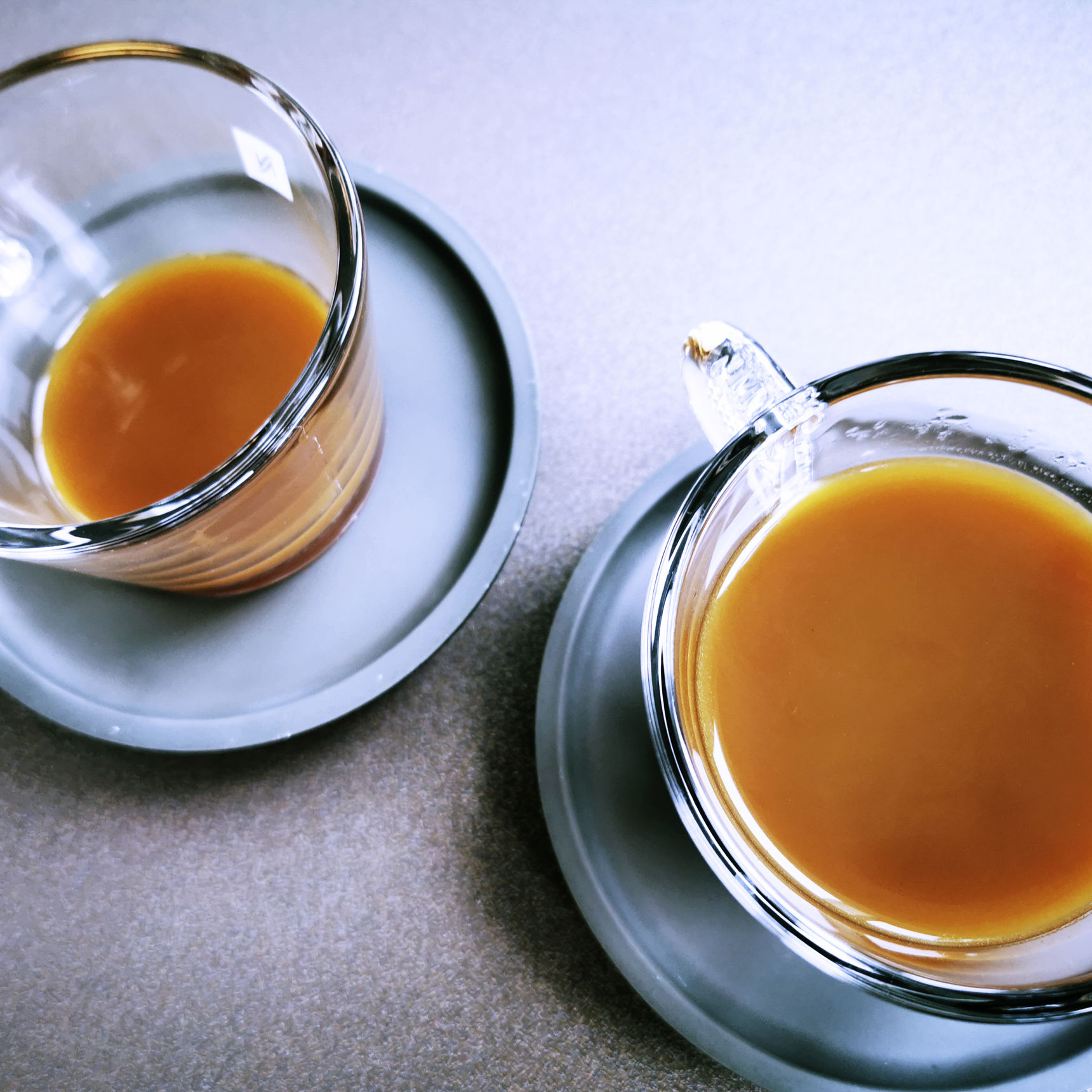 To kopper kaffe i glaskopper. Kaffen er lys - måske med mælk?